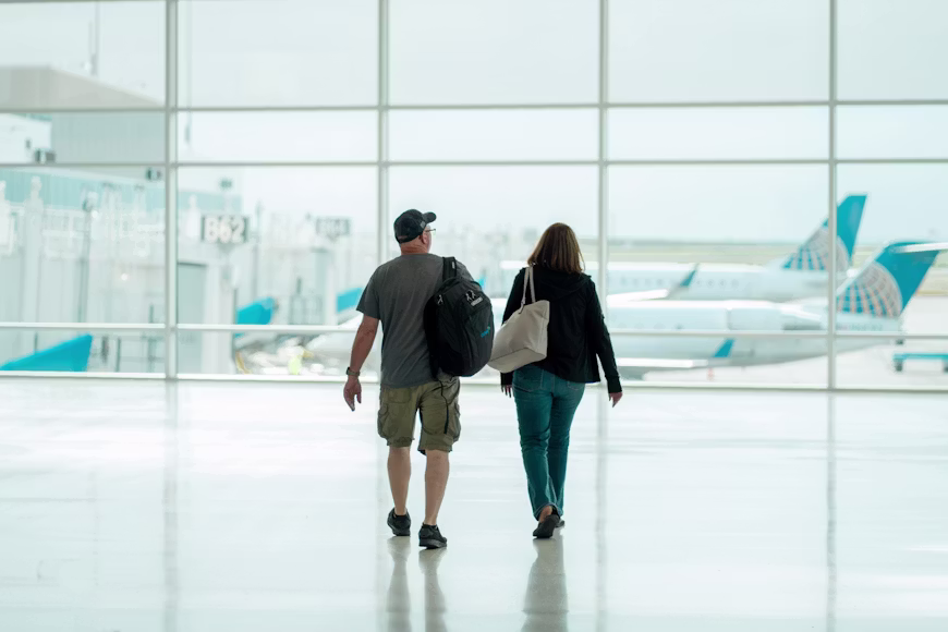 Casal andando pelo saguão do aerporto indo para o checkin